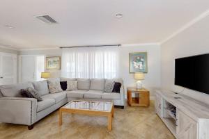 a living room with a couch and a flat screen tv at Seaside Serenity in Punta Gorda
