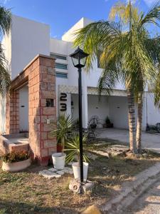 a street light in front of a building with palm trees at Casa completa, 4 dormitorios, 7 camas dobles, 4 sofá cama, 3 baños 1 en planta baja, cocina equipada, consola Arcade, asador, juguetes para niños, plancha, secadora, cafetera, etc, fraccionamiento privado, zona de vías rápidas y toallas in Torreón