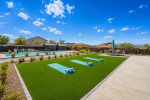 a group of people laying on mats on a lawn at CIELO - Modern Vegas Pool Oasis, Spa, Pickleball in Las Vegas