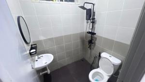 a bathroom with a toilet and a sink at Razumi's Homestay 3 in Arau +4 photos