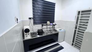 a small bathroom with a sink and a window at Razumi's Homestay 3 in Arau