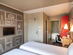 a bedroom with a bed with a drawing on the wall at ibis Saint Gratien - Enghien-Les-Bains in Saint-Gratien