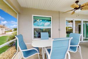a porch with a white table and blue chairs at Waterway Whispers in Rotunda-West