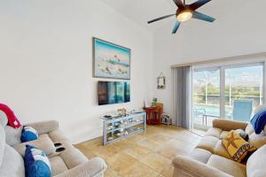 a living room with two couches and a ceiling fan at Waterway Whispers in Rotunda-West