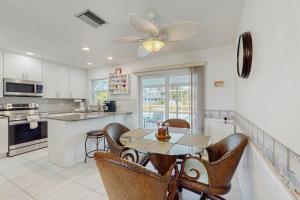 a kitchen with a table and chairs and a ceiling fan at Lil Blue in Punta Gorda