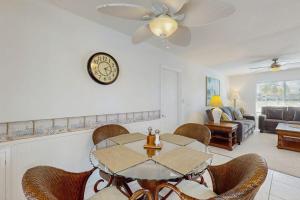 a living room with a table and chairs and a clock at Lil Blue in Punta Gorda