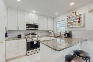a kitchen with white cabinets and a counter top at Lil Blue in Punta Gorda +11 photos