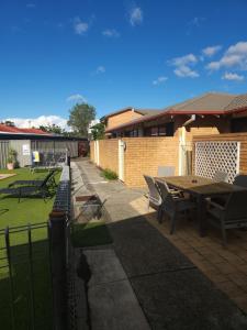 a patio with a table and chairs in a yard at Port O'Call Motel in Port Macquarie