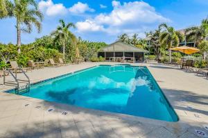 a swimming pool with chairs and a gazebo at Bocilla Breeze in Bokeelia