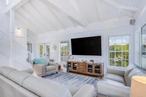 a living room with white furniture and a flat screen tv at Bocilla Breeze in Bokeelia