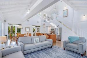 a living room with two couches and a staircase at Bocilla Breeze in Bokeelia