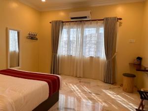 a bedroom with a bed and a window with curtains at UncleLiew Cozy Home 老刘民宿 in Sekinchan +12 photos