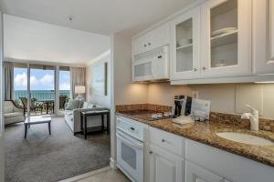 a kitchen with a sink and a living room at Marco Beach Ocean Resort 807 in Marco Island