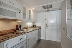 a kitchen with white cabinets and a white door at Marco Beach Ocean Resort 807 in Marco Island +20 photos
