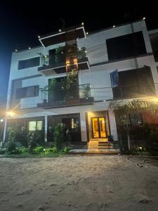a large white building at night with a bench in front at Résidence MBK in Ziguinchor