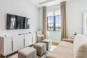 a living room with a couch and a tv on a wall at SoCe Flats 209 in Naples