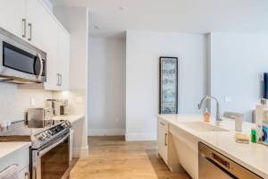 a kitchen with white cabinets and a sink at SoCe Flats 209 in Naples