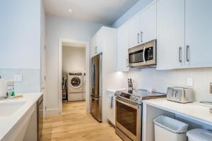 a kitchen with white cabinets and stainless steel appliances at SoCe Flats 209 in Naples +14 photos