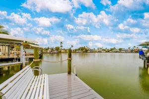 a dock with a bench next to a body of water at Sunset Escape in Marco Island