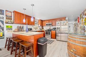 a kitchen with wooden cabinets and stainless steel appliances at Sunset Escape in Marco Island +32 photos