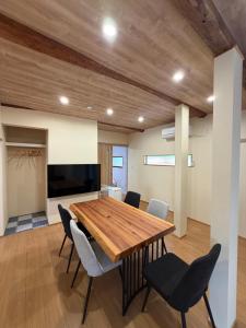 a dining room with a wooden table and chairs at 和風アンドラン in Minamiawaji
