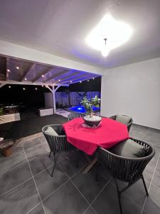 a dining room with a red table and chairs at Golden palm in Rivière-Pilote