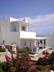 a white house with flowers in front of it at Maison a la Plage in Faros