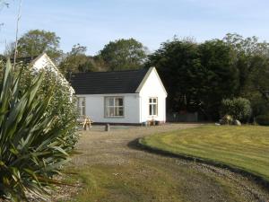 a small white house with a grass yard at WatersEdge in Mulranny