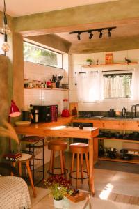a kitchen with a wooden table and some stools at Studio Mata dos Curiós in Petrópolis +27 photos