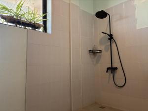 a shower with a shower head in a bathroom at The Lazy Tiki in Buenavista +53 photos
