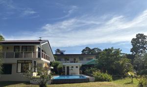 a house with a swimming pool in front of it at The Lazy Tiki in Buenavista