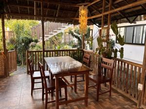 a wooden table and chairs on a wooden deck at The Lazy Tiki in Buenavista