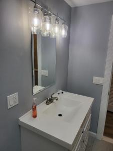a bathroom with a white sink and a mirror at Single Level Spacious Home - A JBMB Property in Middletown +21 photos