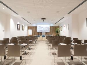 a conference room with tables and chairs and a screen at Mercure Palermo Centro in Palermo