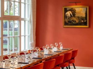 a long table in a room with wine glasses at Mercure Rambouillet Relays Du Château in Rambouillet