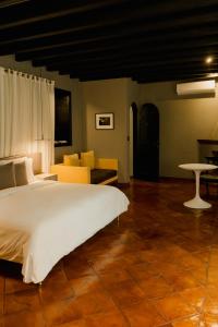 a bedroom with a large white bed and a couch at Dos Casas Hotel & Spa in San Miguel de Allende