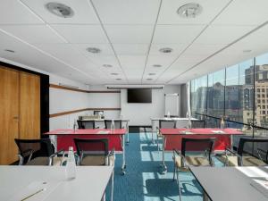 a conference room with tables and chairs and a large window at ibis Kuwait Salmiya in Kuwait