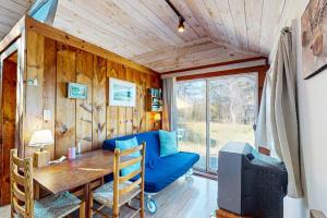 a living room with a table and a blue couch at North Truro Bayside Gem in Truro