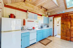 a kitchen with blue cabinets and a white refrigerator at North Truro Bayside Gem in Truro