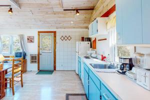 a kitchen with blue cabinets and a white refrigerator at North Truro Bayside Gem in Truro +8 photos