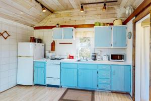 a kitchen with blue cabinets and a white refrigerator at North Truro Bayside Gem in Truro