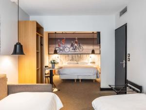 a hotel room with two beds and a poster on the wall at ibis Styles Dinan Centre Ville in Dinan +78 photos