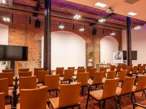 an empty room with chairs and a projection screen at Novotel Cardiff Centre in Cardiff