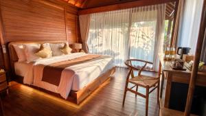 a bedroom with a bed and a desk and a chair at The Woods Uluwatu in Uluwatu +43 photos