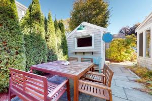 a wooden table with two chairs and a dog house at Seaside Sanctuary in Harwich