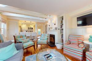 a living room with a couch and chairs and a fireplace at Seaside Sanctuary in Harwich