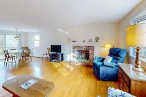 a living room with a blue chair and a fireplace at Corner Cottage in Chatham