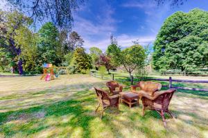 a table and chairs in a field with a playground at Old Mansard in West Dennis