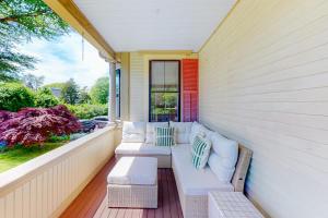 a porch with a white couch and a window at Old Mansard in West Dennis