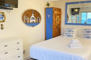 a bedroom with a white bed and a blue door at National Seashore Studio in Truro